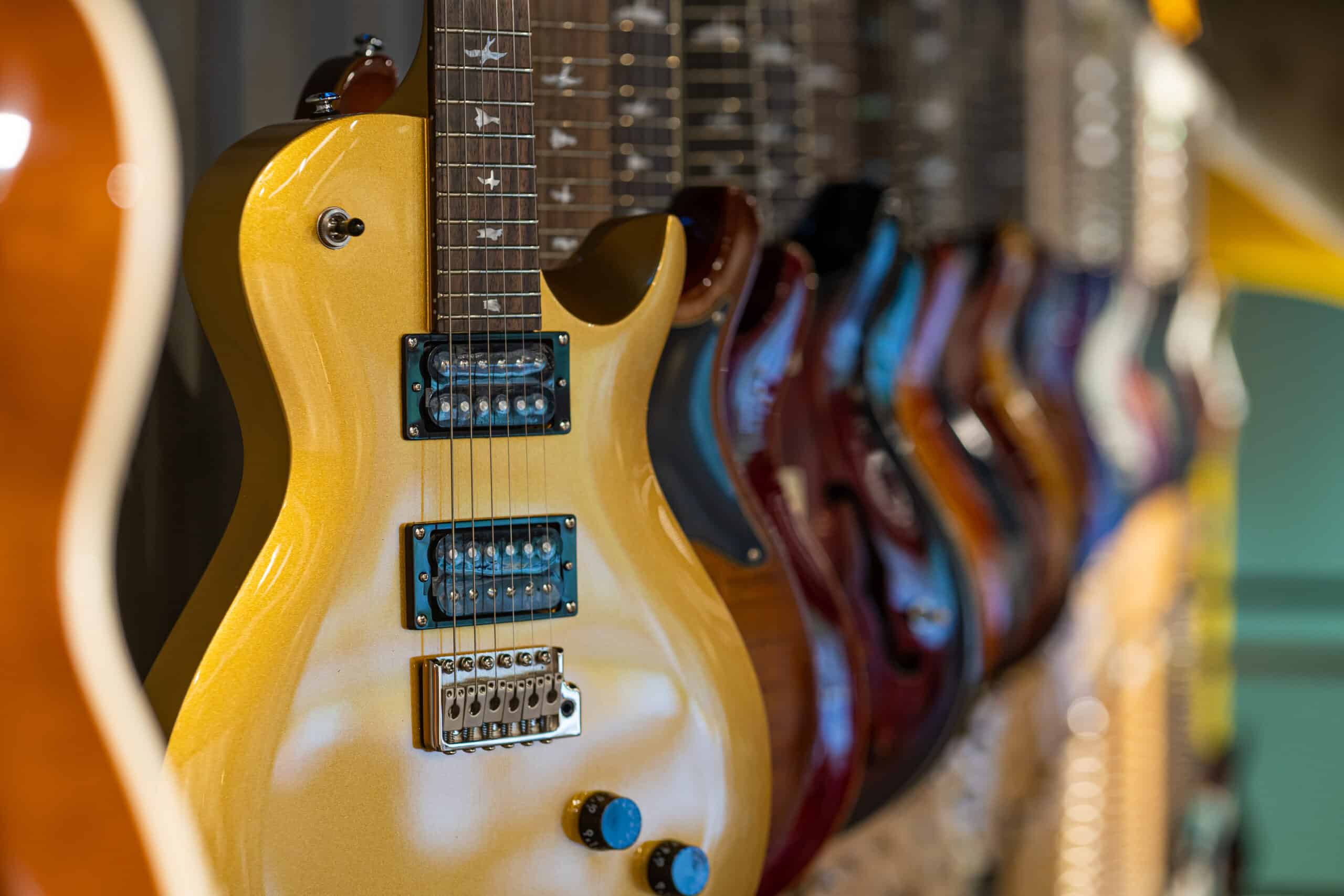 Row of electric guitars different color in a music instruments shop